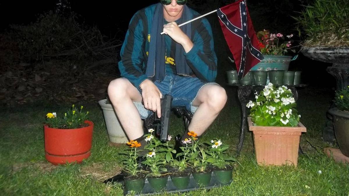 FILE - This undated photo that appeared on Lastrhodesian.com, a website investigated by the FBI in connection with Dylann Roof, shows him posing for a photo holding a Confederate flag. Roof, who would later admit he wanted to start a race war, fatally shot eight black worshippers and their pastor at the Emanuel African Methodist Episcopal Church in Charleston, South Carolina. The following week, Obama delivered the eulogy for the slain Rev. Clementa Pinckney, speaking about the symbolism of the Confederate flag and how racial bias infects everyday life. (Lastrhodesian.com via AP, File)