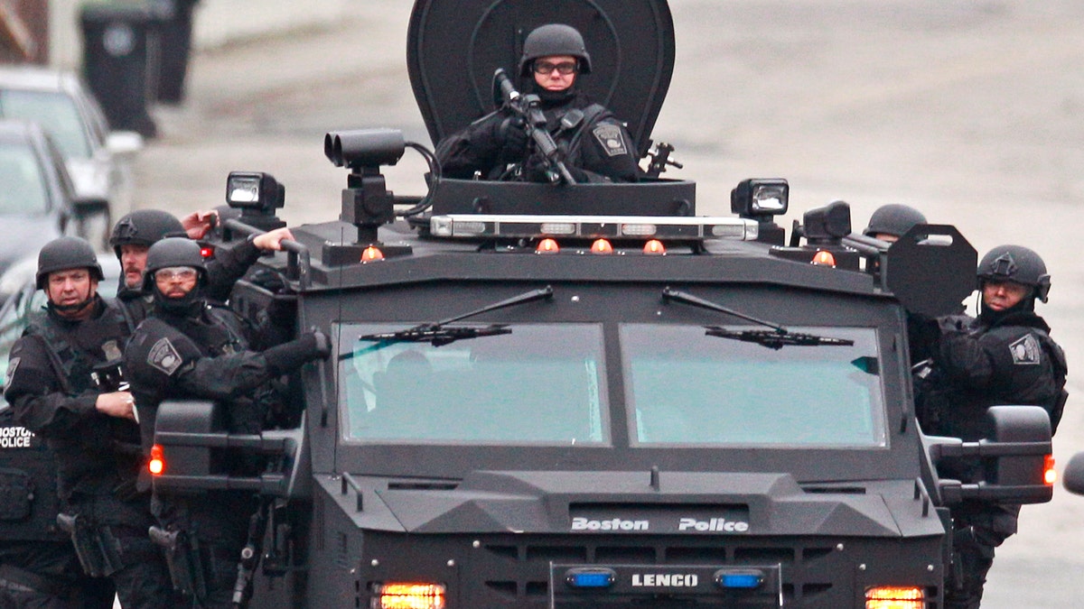 Police patrol through a neighborhood in Watertown, Mass., while searching for a suspect in the Boston Marathon bombings, Friday, April 19, 2013.  All residents of Boston were ordered to stay in their homes Friday morning as the search for the surviving suspect in the marathon bombings continued after a long night of violence that left another suspect dead. (AP Photo/Charles Krupa)