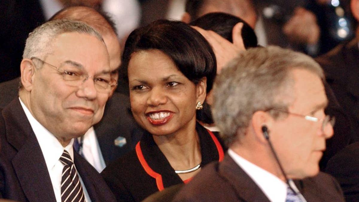 FILE - In this Jan. 13, 2004 file photo, Secretary of State Colin Powell talks with National Security Adviser Condoleezza Rice during the plenary session of the Special Summit of the Americas in Monterrey, Mexico. President Bush sits in the foreground. The national security adviser is the president’s policy whisperer and confidant on military matters, diplomacy, intelligence, terrorism, even the odd hurricane. The adviser usually enjoys unmatched trust with the chief executive and lots of behind-the-scenes clout. (AP Photo/Jaime Puebla, File)