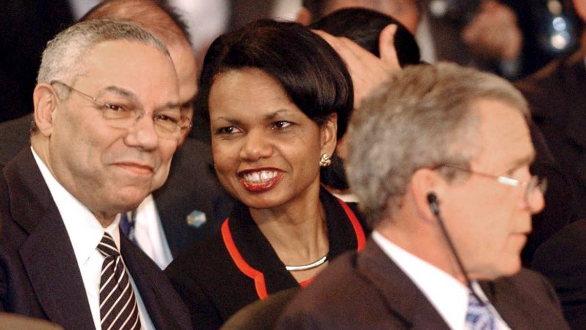 FILE - In this Jan. 13, 2004 file photo, Secretary of State Colin Powell talks with National Security Adviser Condoleezza Rice during the plenary session of the Special Summit of the Americas in Monterrey, Mexico. President Bush sits in the foreground. The national security adviser is the president’s policy whisperer and confidant on military matters, diplomacy, intelligence, terrorism, even the odd hurricane. The adviser usually enjoys unmatched trust with the chief executive and lots of behind-the-scenes clout. (AP Photo/Jaime Puebla, File)