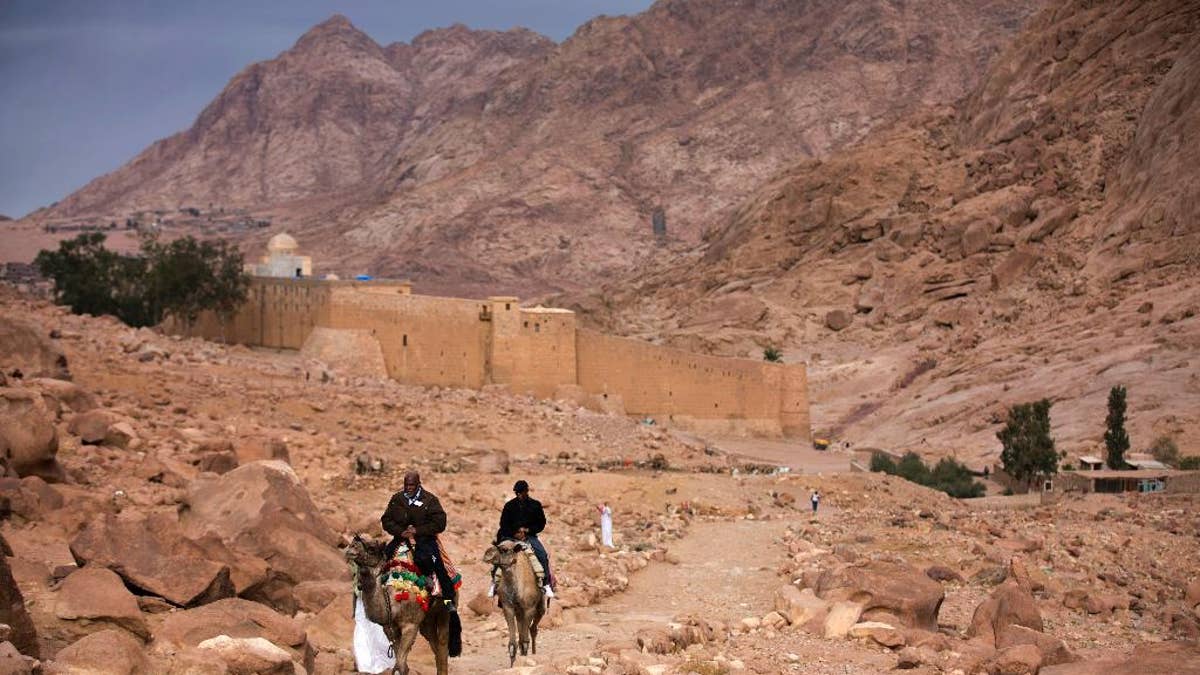 FILE -- In this Dec. 9, 2013 file photo, visitors leave Saint Catherine's Monastery on camels, in Saint Catherine, Egypt. The Islamic State extremist group said Tuesday, April 18, 2017, that its militants carried an attack on a police checkpoint near the famed Monastery in Sinai, which Egyptian security authorities said killed one policeman and wounded four. The attack on the monastery, built in the 6th century and a popular site for tourists visiting the Red Sea resorts along Sinai's southern coast, comes just over a week after suicide bombers attacked two churches in the Nile Delta city of Tanta and the coastal city of Alexandria, killing 45 people on Palm Sunday. (AP Photo/Hiro Komae, File)