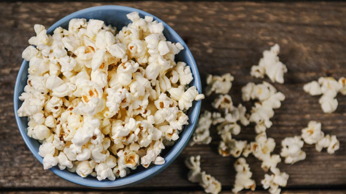 Popcorn in a bowl on wooden table