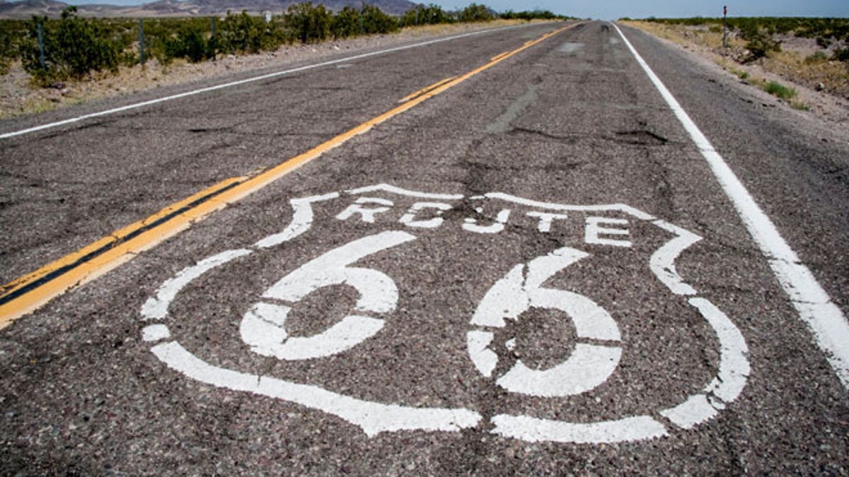 long road with a Route 66 sign painted on it
