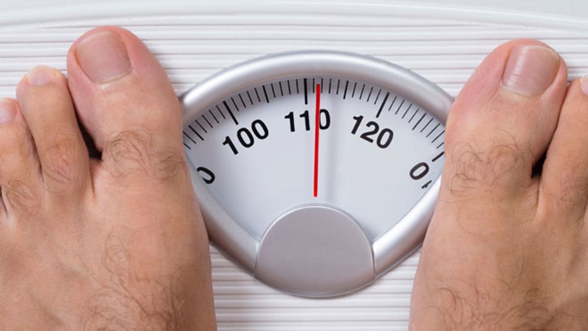 Man's Feet On Weight Scale