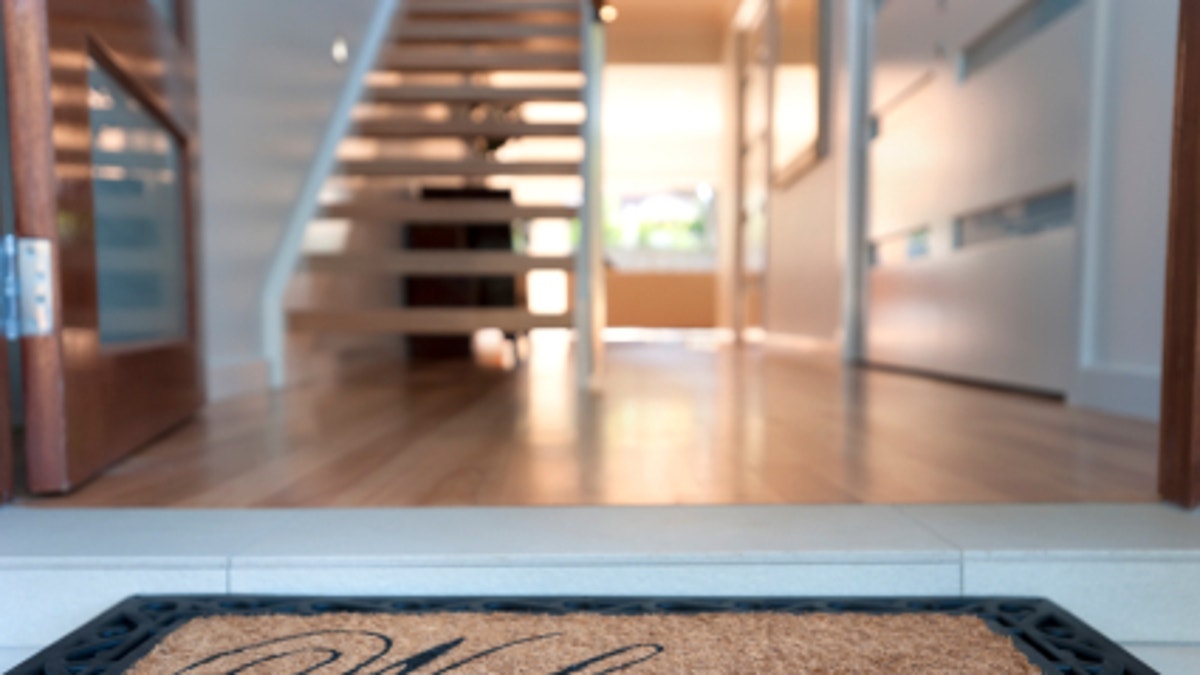 66d9eb01-Close up of a welcome mat in front of an inviting house