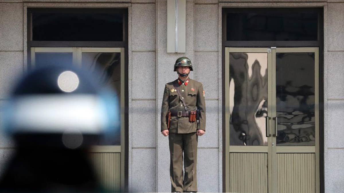 A North Korean soldier looks at the south side as a South Korean soldiers stands guard before U.S. Secretary of State Rex Tillerson arrives at the border village of Panmunjom, which has separated the two Koreas since the Korean War, South Korea, Friday, March 17, 2017. (AP Photo/Lee Jin-man, Pool)