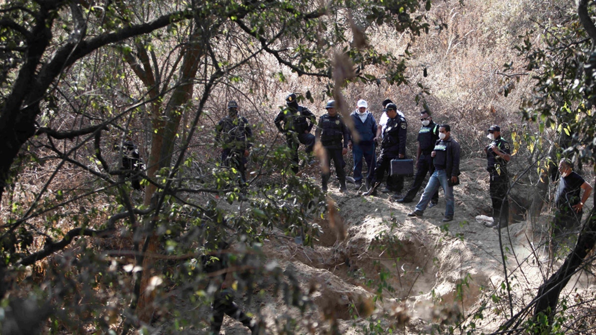 In this Feb. 27, 2011 photo state police guard the site where at least 5 bodies were found in a clandestine grave in Santa María Tlalmanalco on the outskirts of Mexico City. For drug lords, Mexico City has been a favorite hideout and place to launder money, making the sprawling metropolis somewhat of an oasis from the cartel violence along the border and in outlying states. Now a spate of killings and decapitations never before seen have authorities batting down fears that a once-distant drug war is making its way into the capital. (AP Photo/Miguel Tovar)