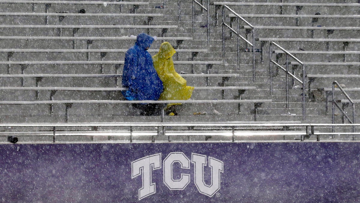 Fans sit in the stands during a thunder delay in the second quarter of an NCAA college football game between Texas and TCU, Saturday, Oct. 26, 2013, in Fort Worth, Texas. (AP Photo/LM Otero)