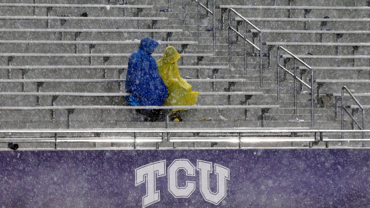 Fans sit in the stands during a thunder delay in the second quarter of an NCAA college football game between Texas and TCU, Saturday, Oct. 26, 2013, in Fort Worth, Texas. (AP Photo/LM Otero)