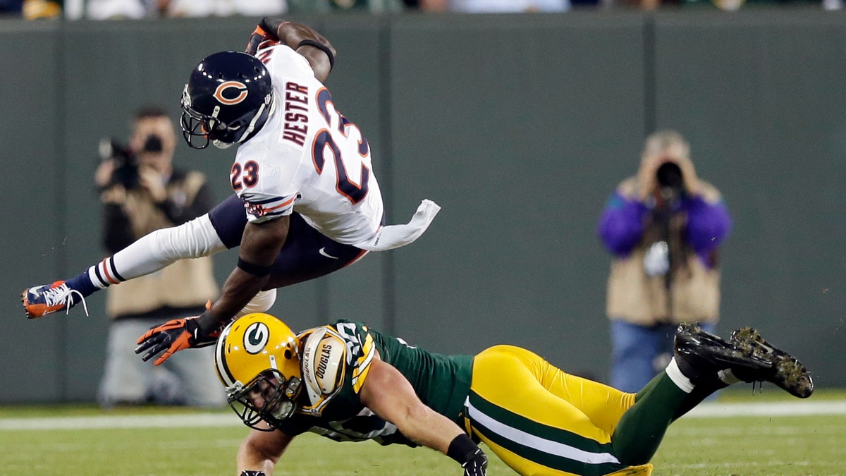 Chicago Bears' Devin Hester (23) is tackled by Green Bay Packers' John Kuhn on a punt return during the second half of an NFL football game Thursday, Sept. 13, 2012, in Green Bay, Wis. (AP Photo/Morry Gash)