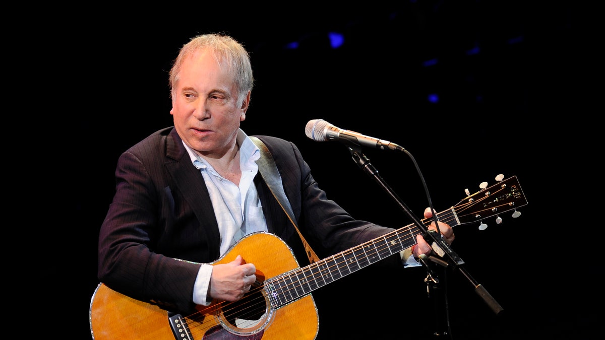 FILE - This April 2, 2012 file photo shows singer Paul Simon performing at "A Celebration of Paul Newman's Dream" to benefit "SeriousFun" an association of Hole in the Wall Camps at Avery Fisher Hall in New York. Police in Connecticut say Paul Simon and his wife, singer Edie Brickell, have been arrested on disorderly conduct charges. A New Canaan police spokeswoman provided no other details, except to say the arrests stemmed from an incident Saturday. An arraignment in Norwalk Superior Court is expected Monday afternoon. Simon is a 12-time Grammy winner and a member of The Songwriters Hall of Fame and the Rock n' Roll Hall of Fame ? as half of the duo of Simon and Garfunkel and as a solo artist. Brickell's "What I Am," recorded with her band the New Bohemians, was a hit in 1988. The two were married in 1992.