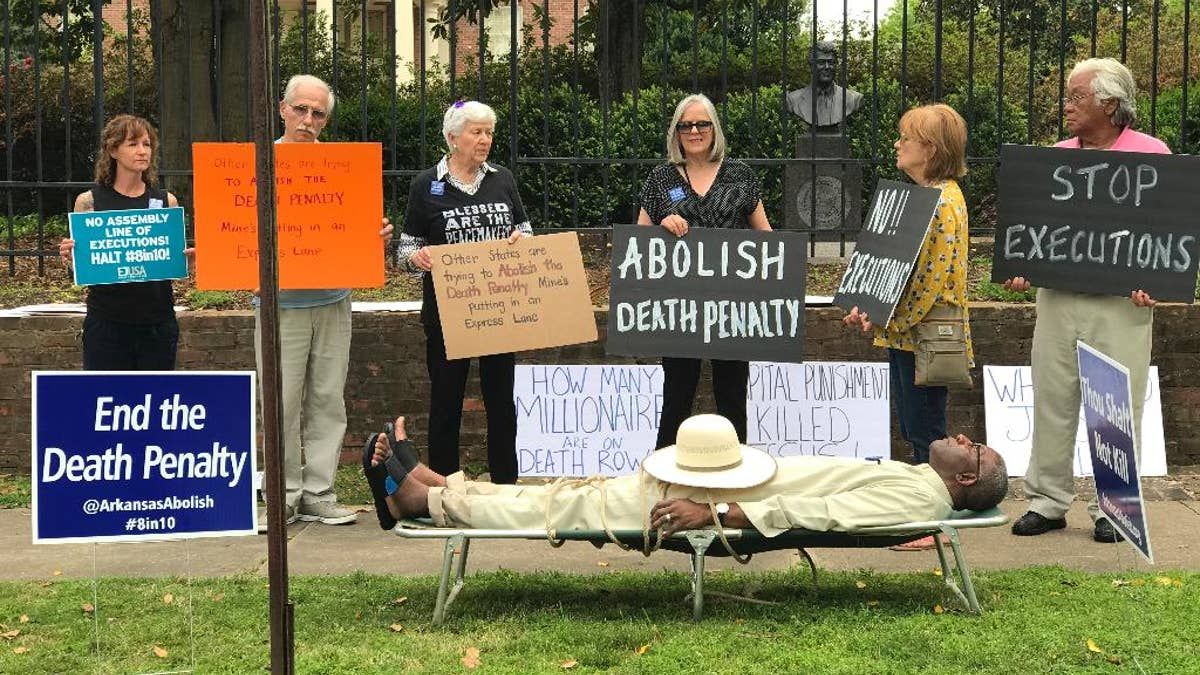 This photo provided by Cheryl Simon shows Pulaski County Circuit Judge Wendell Griffen taking part of an anti-death penalty demonstration outside the Governor's Mansion Friday, April 14, 2017 in Little Rock, Ark.  Griffen issued a temporary restraining order Friday blocking the state from using its supply of vecuronium bromide after a company said it had sold the drug to the state for medical purposes, not capital punishment.   Local media outlets had tweeted photos and video of Griffen appearing to mimic an inmate strapped to a gurney at the demonstration.   Attorney General Leslie Rutledge's office said she planned to file an emergency request with the state Supreme Court to vacate Griffen's order, saying Griffen shouldn't handle the case.  (Cheryl Simon via AP)