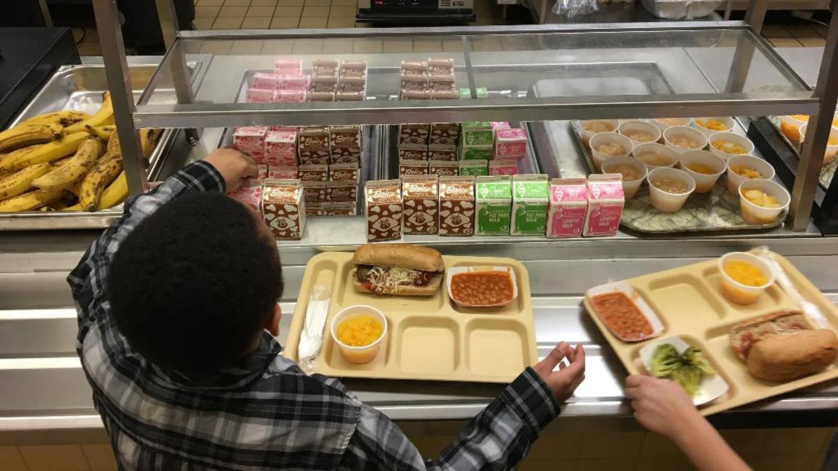 FILE - In this Jan. 25, 2017, file photo, students fill their lunch trays at J.F.K Elementary School in Kingston, N.Y., where all meals are now free under the federal Community Eligibility Provision. A donor inspired by a tweet raised money to pay off lunch debt in districts around the country, as well as thousands of dollars in overdue lunch fees at other schools in the Kingston district. (AP Photo/Mary Esch, File)