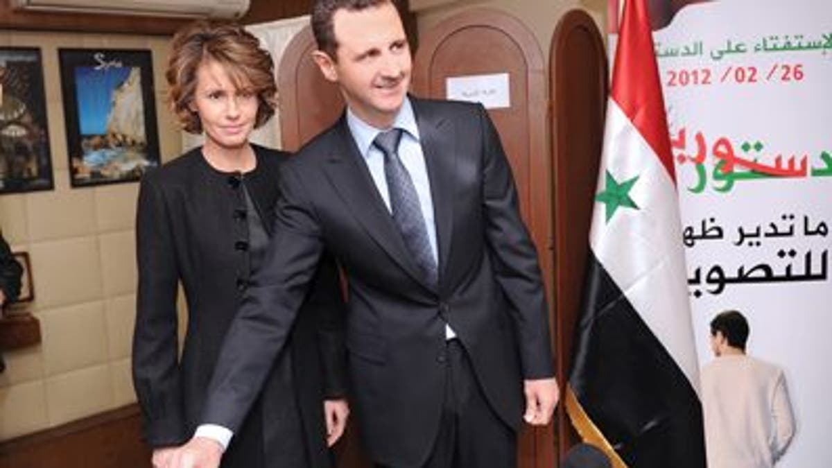 Feb. 26, 2012: In this photo released by the Syrian official news agency SANA, Syrian President Bashar Assad casts his ballot next to his wife Asma at a polling station during a referendum on the new constitution, in Damascus, Syria. 