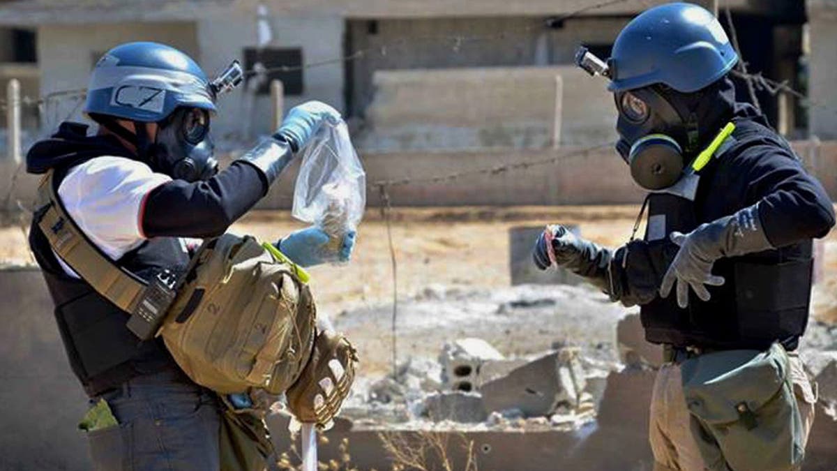 FILE - In this Wednesday, Aug. 28, 2013 citizen journalism file image provided by the United Media office of Arbeen, which has been authenticated based on its contents and other AP reporting, members of a chemical weapons investigation team take samples from sand near a part of a missile that is likely to be one of the chemical rockets, according to activists, in the Damascus countryside of Ain Terma, Syria. The Organization for the Prohibition of Chemical Weapons won the Nobel Peace Prize on Friday, Oct. 11, 2013, for working to eliminate the scourge that has haunted generations from World War I to the battlefields of Syria. (AP Photo/United Media office of Arbeen, File)