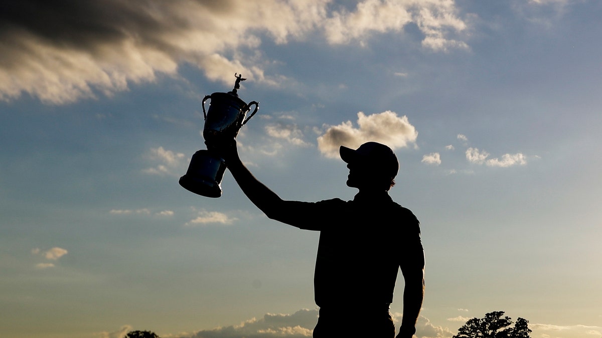 Brooks Koepka poses with the winning trophy after the U.S. Open golf tournament Sunday, June 18, 2017, at Erin Hills in Erin, Wis. (AP Photo/Chris Carlson)