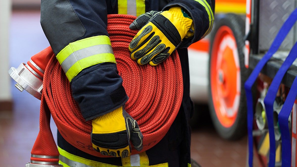 Firefighter wearing a rolled fire hose