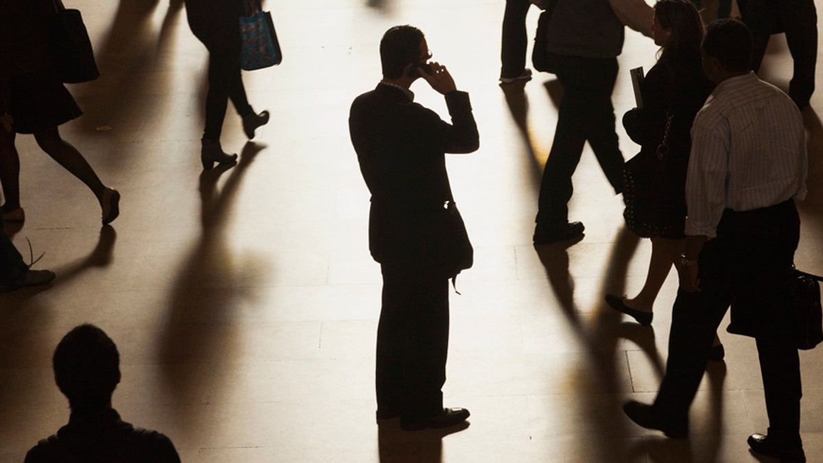 A man stands in the middle of Grand Central Terminal as he speaks on a cell phone, as passengers face limited train service on the New Haven Line between Stamford Station and Grand Central Terminal.