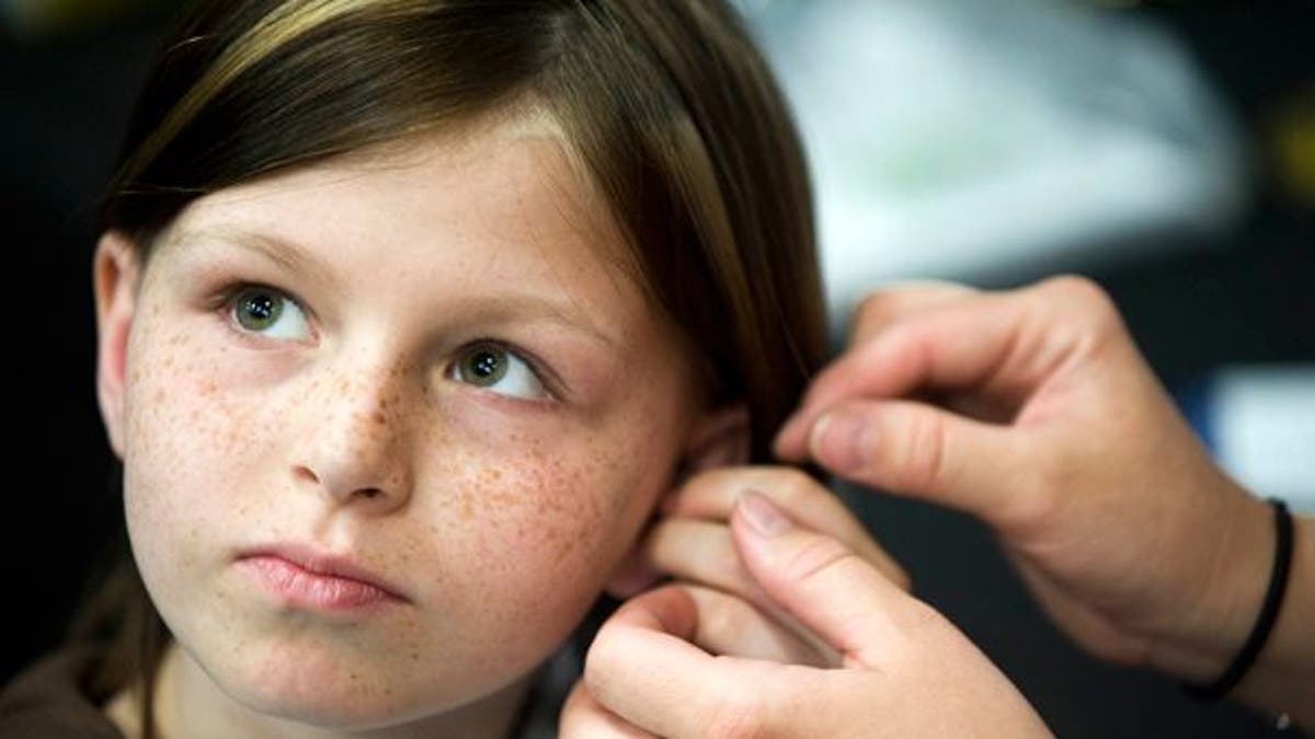 This May 2010 photo shows Zahra Baker, 10, getting a hearing aid at an event at Charlotte Motor Speedway.