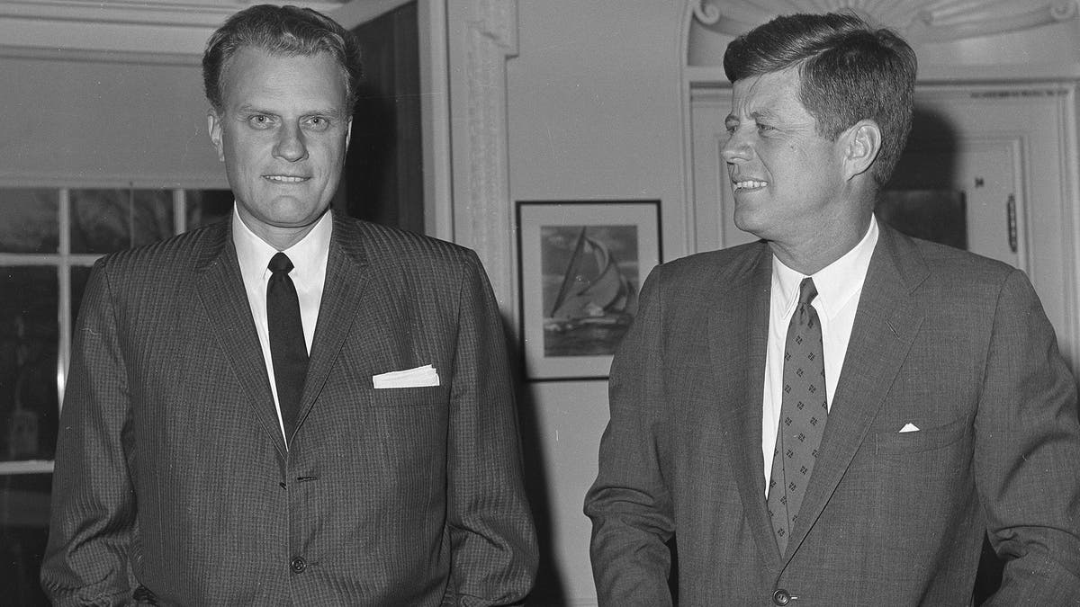 FILE - In this Dec. 12, 1961 file photo, Evangelist Billy Graham, left, talks with President John F. Kennedy during a call at the the White House in Washington. Graham, who transformed American religious life through his preaching and activism, becoming a counselor to presidents and the most widely heard Christian evangelist in history, has died. Spokesman Mark DeMoss says Graham, who long suffered from cancer, pneumonia and other ailments, died at his home in North Carolina on Wednesday, Feb. 21, 2018. He was 99. (AP Photo, File)
