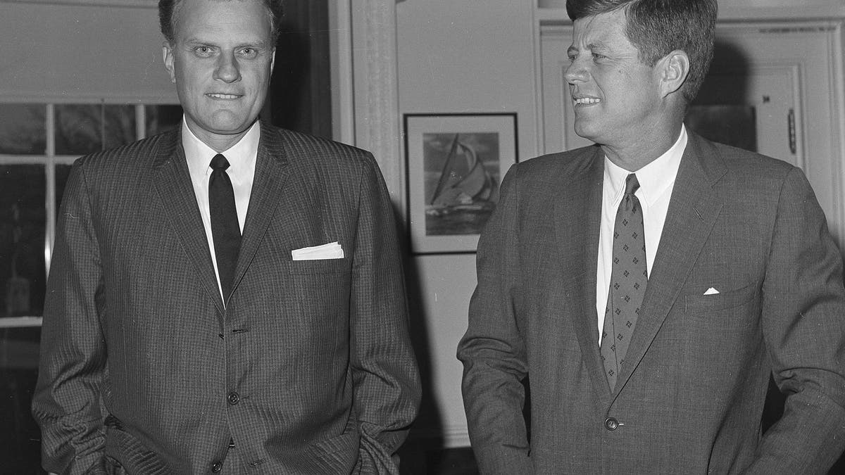 FILE - In this Dec. 12, 1961 file photo, Evangelist Billy Graham, left, talks with President John F. Kennedy during a call at the the White House in Washington. Graham, who transformed American religious life through his preaching and activism, becoming a counselor to presidents and the most widely heard Christian evangelist in history, has died. Spokesman Mark DeMoss says Graham, who long suffered from cancer, pneumonia and other ailments, died at his home in North Carolina on Wednesday, Feb. 21, 2018. He was 99. (AP Photo, File)