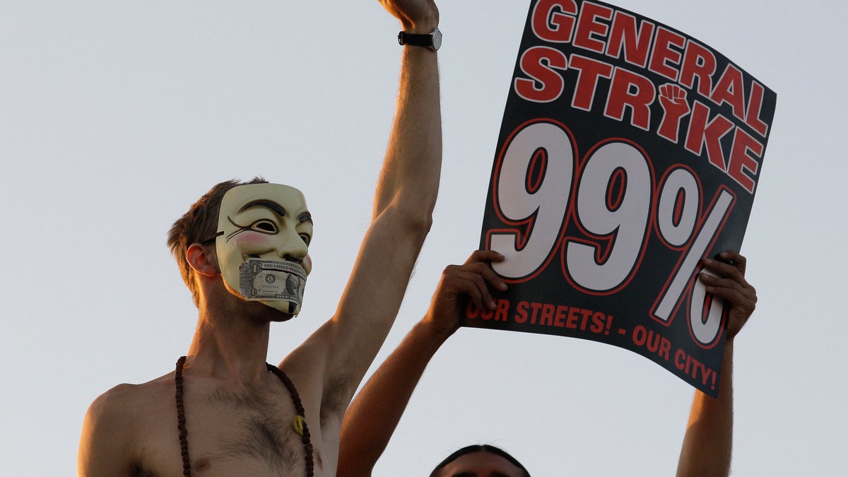 In this Nov. 2, 2011 photo, Occupy Wall Street protestors stand on top of a parked semi truck during a march from downtown Oakland, Calif., to the port of Oakland. From New York to San Francisco to London, some of the demonstrators decrying a variety of society's ills are sporting stylized masks loosely modeled on a 17th-century English terrorist, whether they know it or not. The masks come from "V for Vendetta," a comic-based movie whose violent, anarchist antihero fashions himself as a modern Guy Fawkes, the Catholic insurrectionist executed four centuries ago for trying to blow up Parliament. (AP Photo/Jeff Chiu)