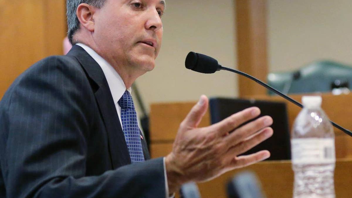 FILE - In this July 29, 2015, file photo, Texas Attorney General Ken Paxton speaks during a hearing in Austin, Texas. On the brink of bringing Paxton to trial on felony securities fraud charges, the government's prosecutors are threatening to bail out of the case unless they get paid. Paxton, a stockbroker and state lawmaker before being elected attorney general two years ago, was indicted for allegedly steering investors to a technology startup in 2011 without disclosing that he was being paid by the company. The trial is scheduled to start May 1, 2017. (AP Photo/Eric Gay, File)