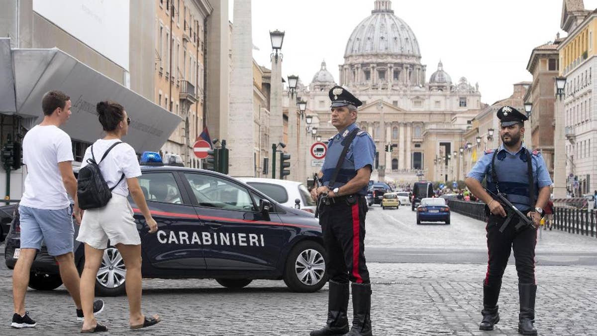 Carabinieri (Italian paramilitary police) officers patrol the area in front of St. Peter's Basilica, visible in background, in Rome, Friday, Aug. 5, 2016. Anti-terrorism measures have been tightened in Rome. They include the stationing of police cars and van at the end of a boulevard that runs past the Colosseum, and police patrols and surveillance along Via del Corso, a long street lined with clothing shops and which also runs by the premier’s office. (Claudio Peri/ANSA via AP)