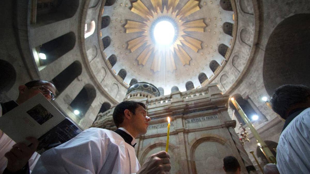 Christian pilgrims light candles during the Easter Sunday procession at the Church of the Holy Sepulchre, traditionally believed by many Christians to be the site of the crucifixion and burial of Jesus Christ, in Jerusalem, Sunday, April 16, 2017. Millions of Christians around the world are celebrating Easter commemorating the day when according to Christian tradition Jesus was resurrected in Jerusalem. (AP Photo/Sebastian Scheiner)