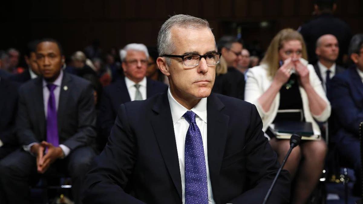 Acting FBI Director Andrew McCabe sits with a folder marked 