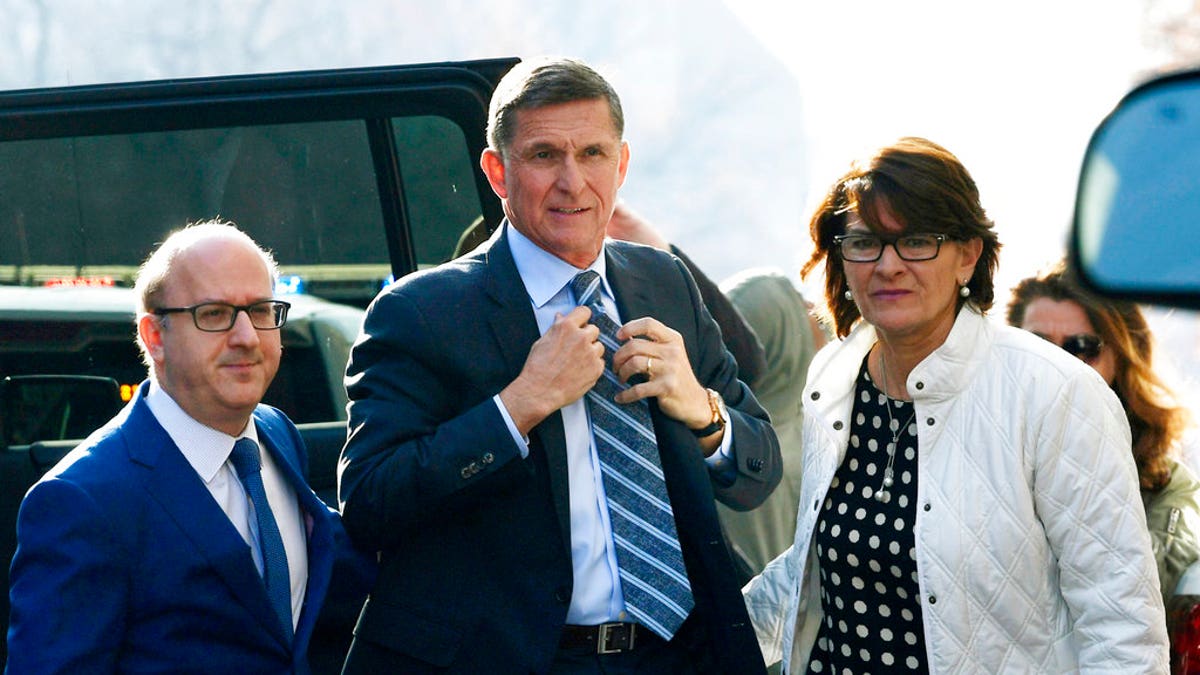 Former Trump national security adviser Michael Flynn, center, arrives at federal court in Washington, Friday, Dec. 1, 2017. Court documents show Flynn, an early and vocal supporter on the campaign trail of President Donald Trump whose business dealings and foreign interactions made him a central focus of Mueller's investigation, will admit to lying about his conversations with Russia's ambassador to the United States during the transition period before Trump's inauguration.  (AP Photo/Susan Walsh)