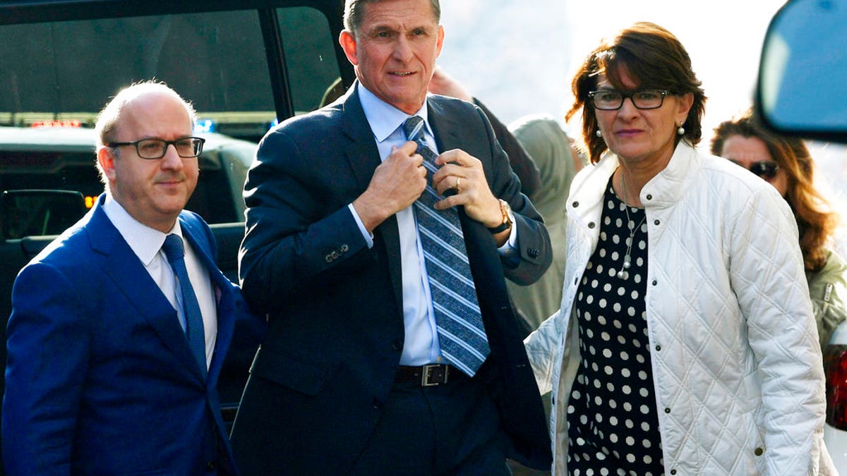 Former Trump national security adviser Michael Flynn, center, arrives at federal court in Washington, Friday, Dec. 1, 2017. Court documents show Flynn, an early and vocal supporter on the campaign trail of President Donald Trump whose business dealings and foreign interactions made him a central focus of Mueller's investigation, will admit to lying about his conversations with Russia's ambassador to the United States during the transition period before Trump's inauguration.  (AP Photo/Susan Walsh)