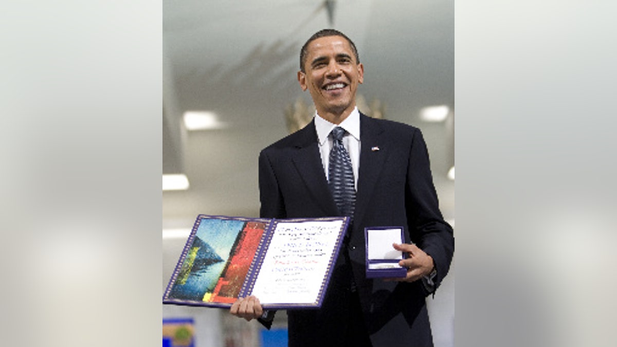 US President and Nobel Peace Prize laureate Barack Obama, holds his medal and diploma at the Nobel Peace Prize ceremony at City Hall in Oslo, Thursday, Dec. 10, 2009. (AP Photo Bjorn Sigurdson/ Scanpix Norway, Pool)
