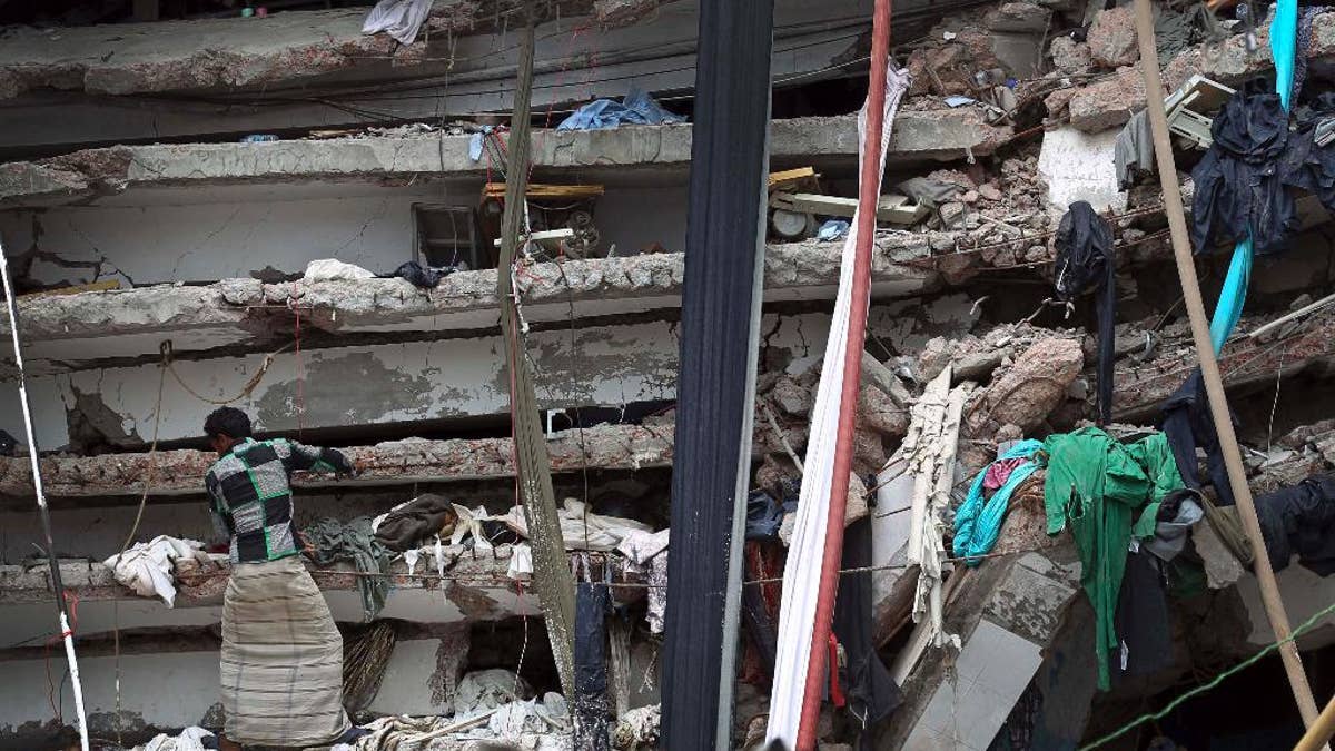 FILE- In this April 30, 2013 file photo, a worker toils in a collapsed garment factory building in Savar, near Dhaka, Bangladesh. Authorities in Bangladesh said they will file murder charges against 41 people including the building's owner,  Sohel Rana, and his parents and more than a dozen government officials, for their direct role behind the deaths of 1,137 people in the collapse of Rana Plaza. (AP Photo/A.M.Ahad, File)