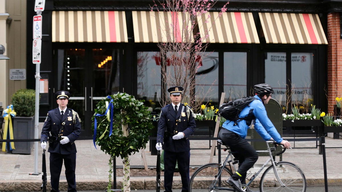 A Boston Police honor guard is posted outside the Forum restaurant, the site of the second of two bombs that exploded near the finish line of the 2013 Boston Marathon, Tuesday, April 15, 2014 in Boston. Three were killed and more than 260 injured in last year's explosions near the finish line of the race. (AP Photo/Charles Krupa)