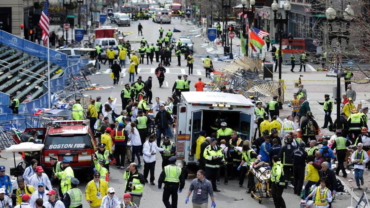 FILE - In this April 15, 2013, file photo, medical workers aid injured people at the finish line of the 2013 Boston Marathon following an explosion in Boston. Jury selection for bombing suspect Dzhokhar Tsarnaev's trial is scheduled to begin Monday, Jan. 5, 2015, in federal court in Boston. (AP Photo/Charles Krupa, File)