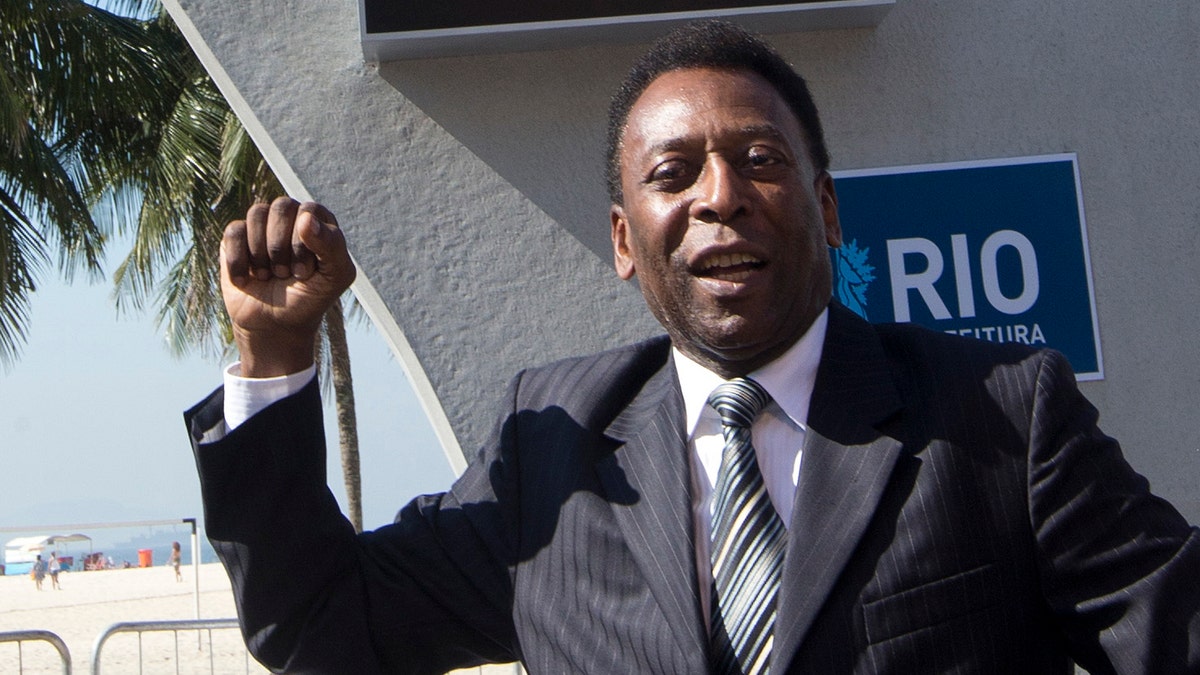 Brazilian football icon Pele cheers during the unveiling of the Hublot Countdown Clock designed by the late architect Oscar Niemeyer, at the Copacabana beach in Rio de Janeiro, Brazil, Wednesday, June 12, 2013. The event marks the start of the one-year countdown to the opening 2014 World Cup game in Brazil. (AP Photo/Silvia Izquierdo)