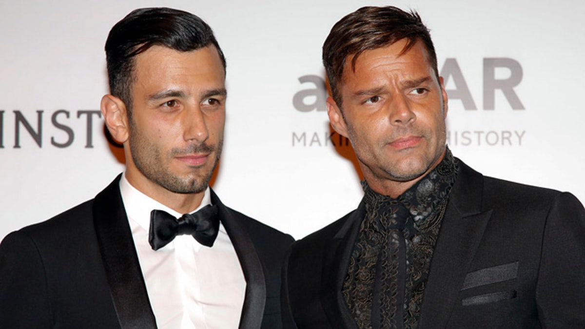 Singer Ricky Martin, right, and artist Jwan Yosef pose on the red carpet of The Foundation for AIDS Research (amfAR) event in Sao Paulo, Brazil, Friday, April 15, 2016. (AP Photo/Andre Penner)