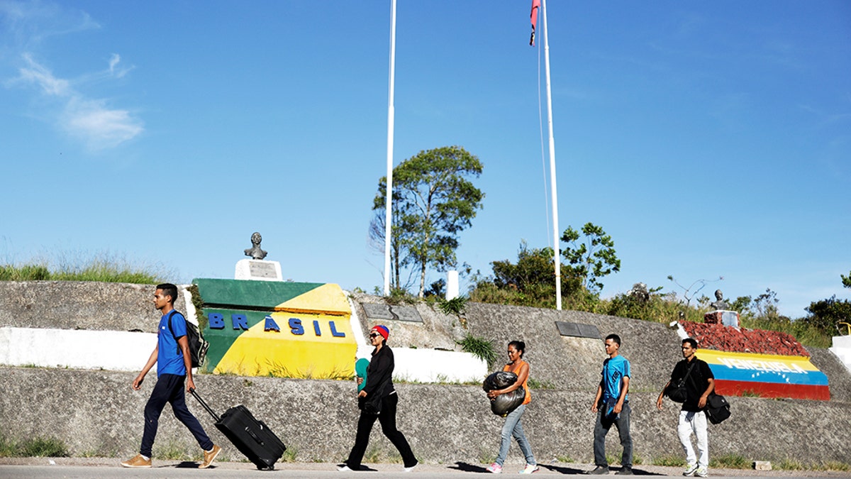 Venezuelans walk across the border from Venezuela into the Brazilian city of Pacaraima. Reuters
