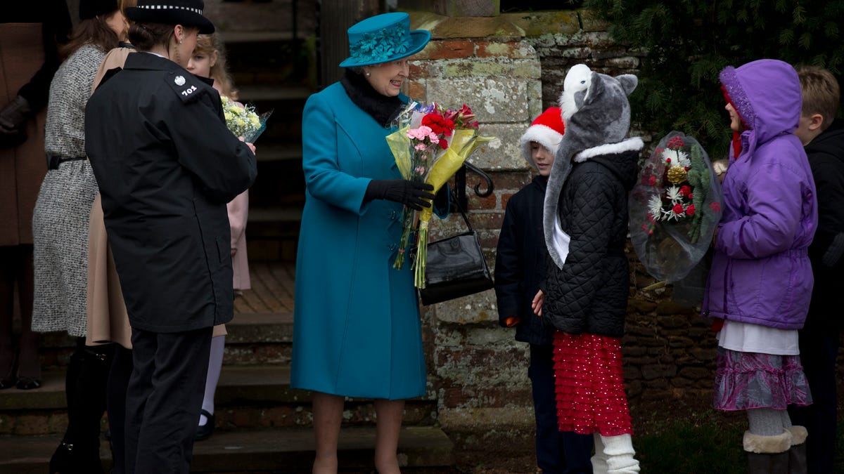 Britain's Queen Elizabeth II smiles as she receives flowers from children after attending the traditional Christmas Day church service in Sandringham, England.