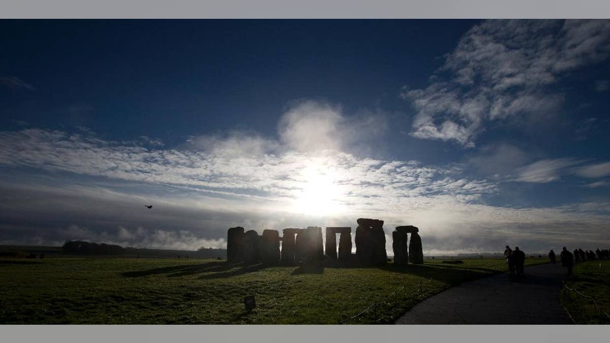 FILE - In this Tuesday Dec. 17, 2013 file photo, visitors take photographs of the world heritage site of Stonehenge, England. Researchers have discovered evidence of standing stones believed to be the remnants of a major prehistoric stone monument near the Stonehenge ruins. University of Bradford researchers said Monday Sept. 7, 2015 the monument is thought to have been built around 4,500 years ago. (AP Photo/Alastair Grant, File)