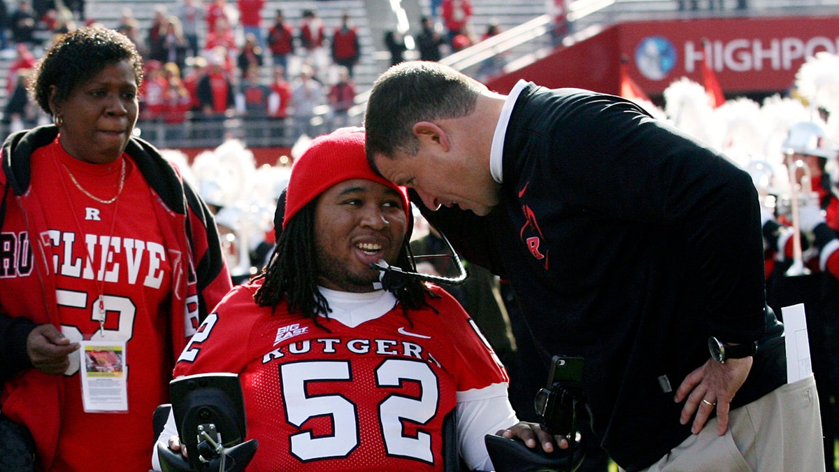 Nov. 19, 2011: In this file photo, paralyzed former Rutgers football player Eric LeGrand, center, is greeted by coach Greg Schiano, right, before an NCAA college football game against Cincinnati in Piscataway, N.J. 