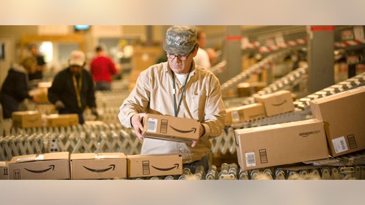 FILE - In this Monday, Dec., 1, 2008, file photo, an Amazon.com employee grabs boxes off the conveyor belt to load in a truck at their Fernley, Nev., warehouse. Cyber Monday, coined in 2005 by a shopping trade group that noticed a spike in online sales on the Monday after Thanksgiving when people returned to their work computers, is the next in a line of days that stores are counting on to jumpstart the holiday shopping season. This year it is expected to be the biggest online shopping day of the year for the third year in a row. (AP Photo/Scott Sady)