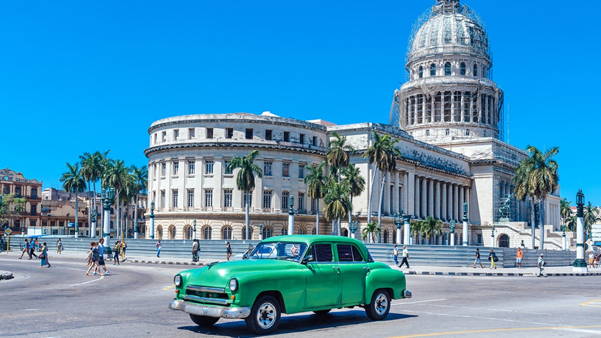 Old American car driving at a street of old Havana, Cuba