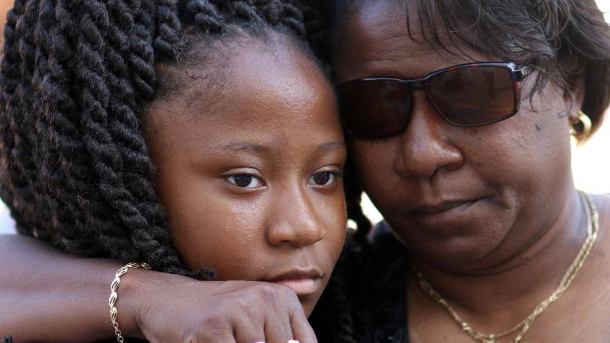 Antonee Martin, left, and her mother Latrechia Jackson, right, visit the memorial site set up in front of the Emanuel AME Churchin June, 2015, after Martin's aunt Susie Jackson was killed.