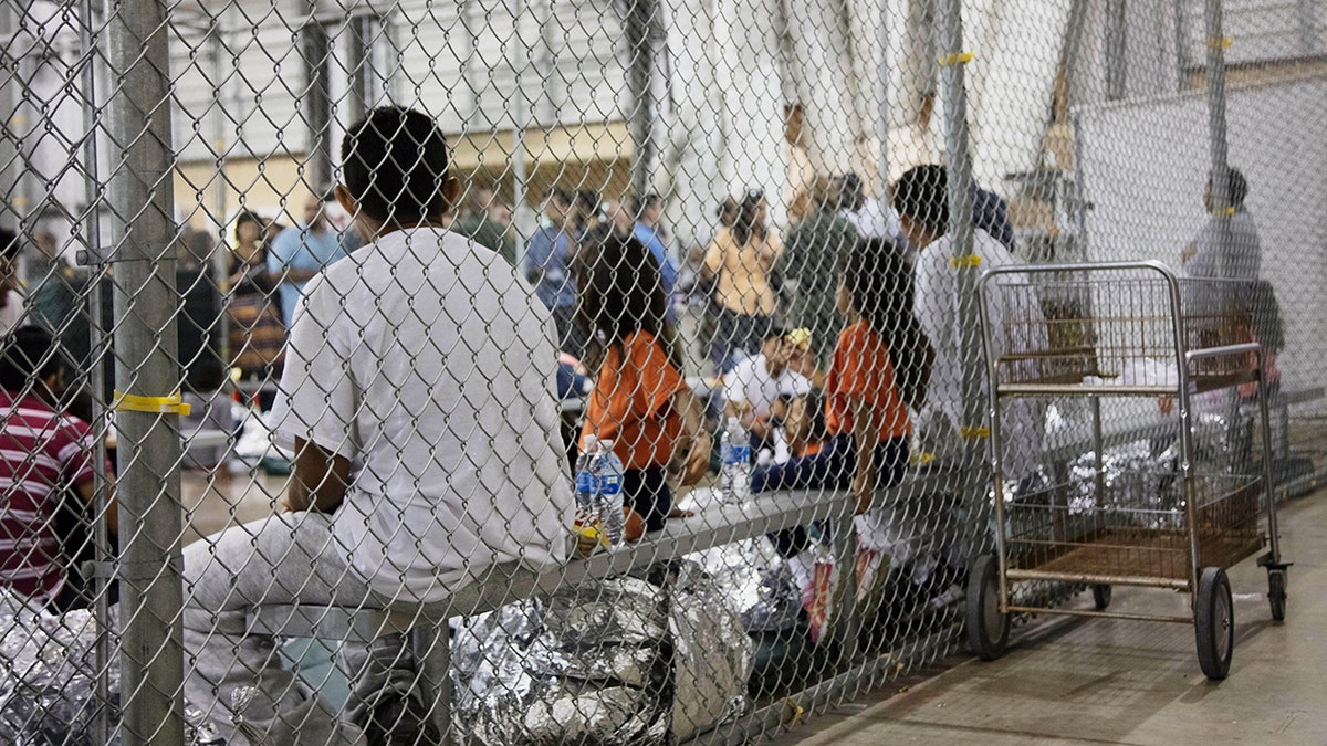 In this photo provided by U.S. Customs and Border Protection, people who've been taken into custody related to cases of illegal entry into the United States, sit in one of the cages at a facility in McAllen, Texas, Sunday, June 17, 2018. (U.S. Customs and Border Protection's Rio Grande Valley Sector via AP)