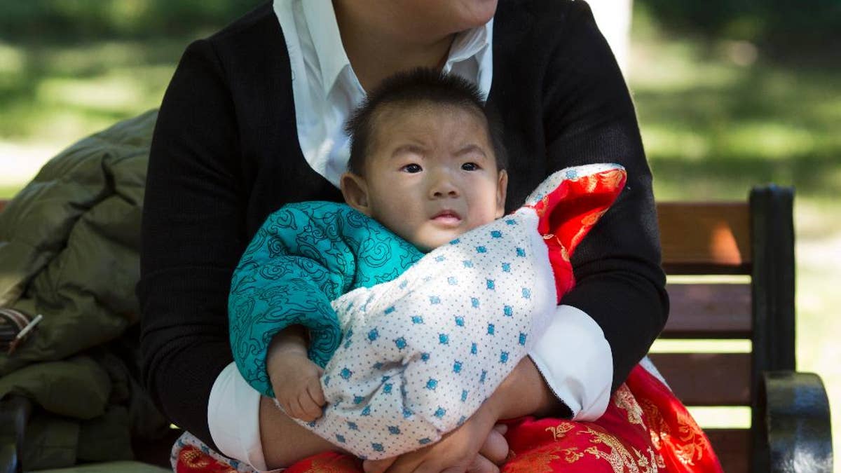 A child is wrapped up against the cold at a park in Beijing, China