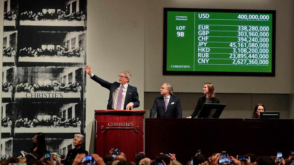 CORRECTS PRICE - Christie's auctioneer Jussi Pylkannen, left, looks for one last bid for Leonardo da Vinci's 