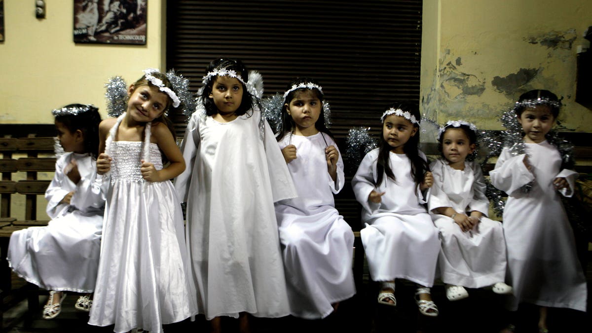 Children dressed as angels wait to perform in a Christmas Nativity at Trinidad neighborhood in Asuncion, Paraguay, Thursday, Dec. 22, 2011. (AP Photo/Jorge Saenz)