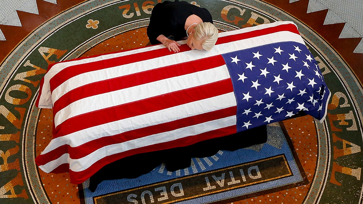 Cindy McCain, wife of, Sen. John McCain, R-Ariz. lays her head on casket during a memorial service at the Arizona Capitol on Wednesday, Aug. 29, 2018, in Phoenix